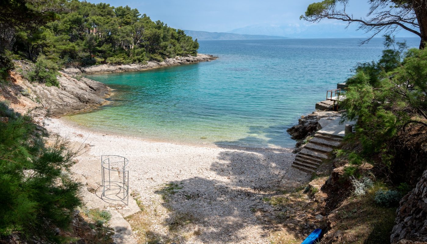 a sandy beach with steps leading to the water